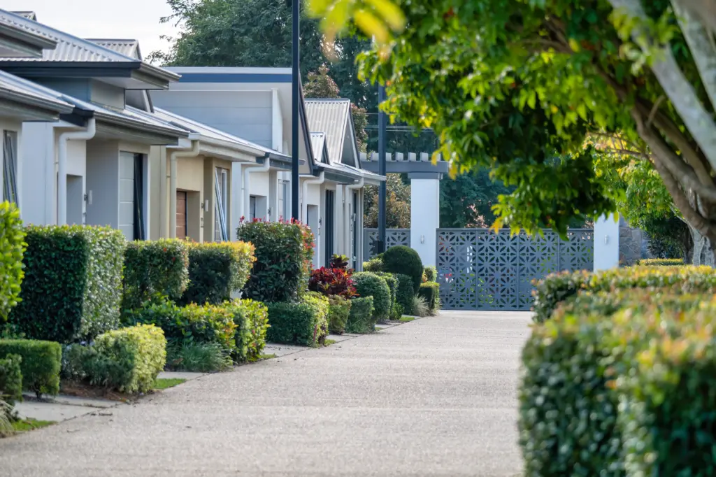 Modern townhouses with manicured hedges and driveway