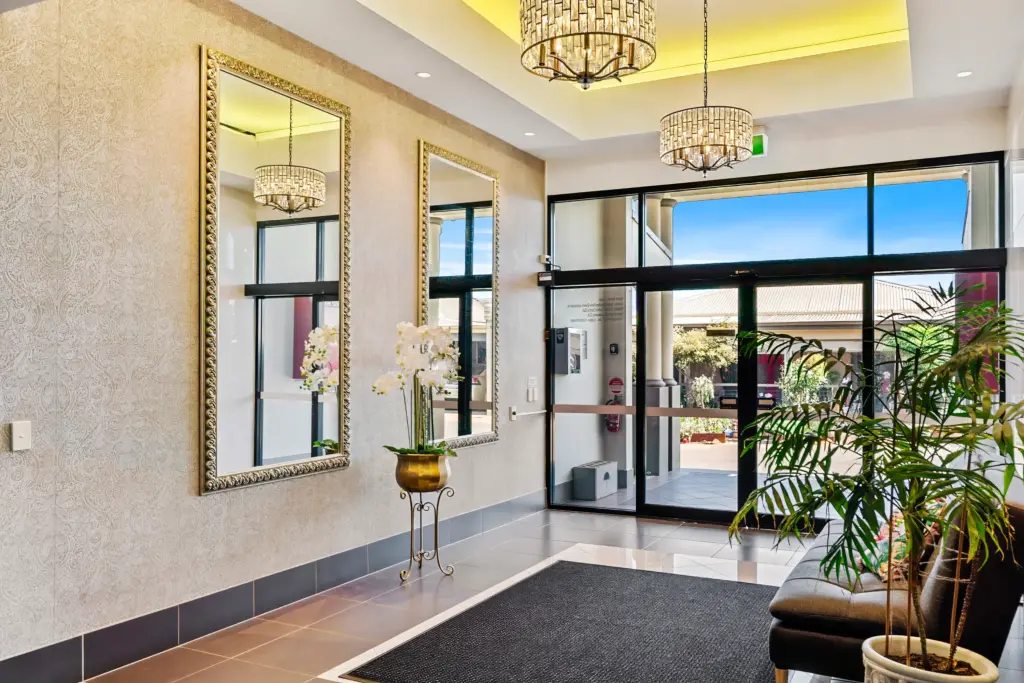 Elegant lobby with mirrors, chandeliers and glass entrance