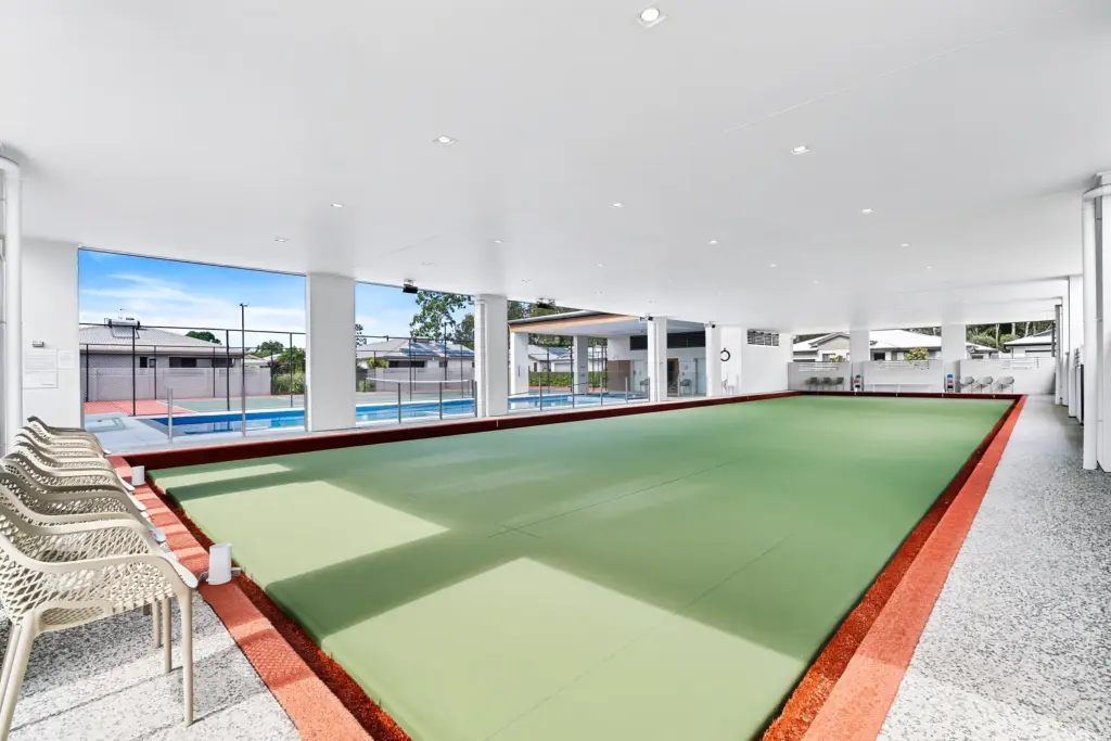 Covered lawn bowls green beside pool and tennis court