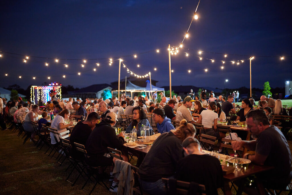 Grants & Sponsorship AVID Property Group long table event outside with lights.