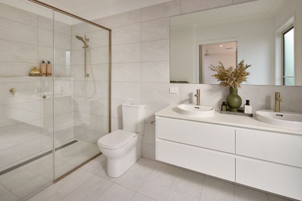 Modern white bathroom with double vanity and glass shower