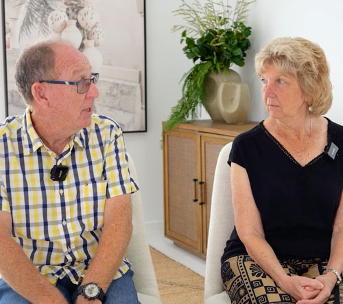 Older couple seated indoors having a conversation