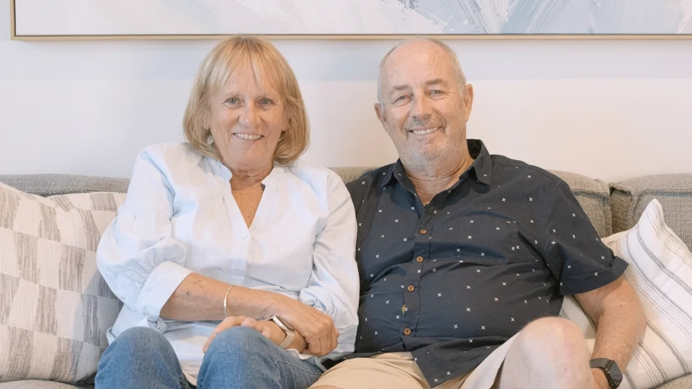 Smiling older couple seated together on a lounge