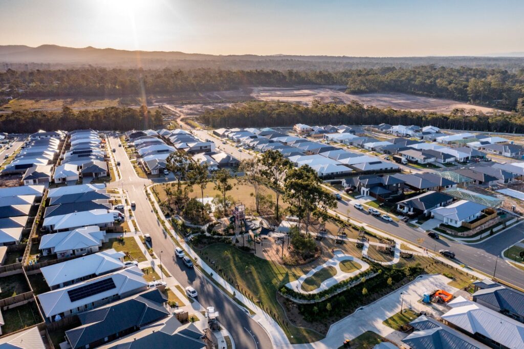 Aerial view of suburban homes, park and surrounding bushland