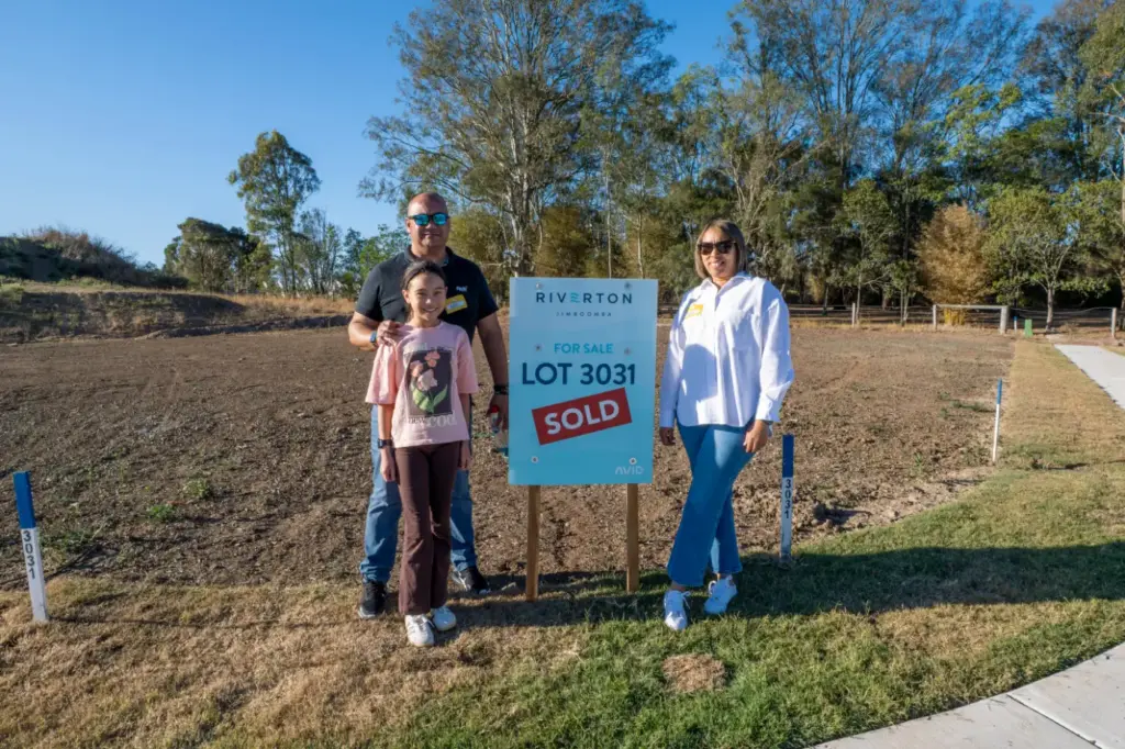 Family beside sold Lot 3031 sign at Riverton