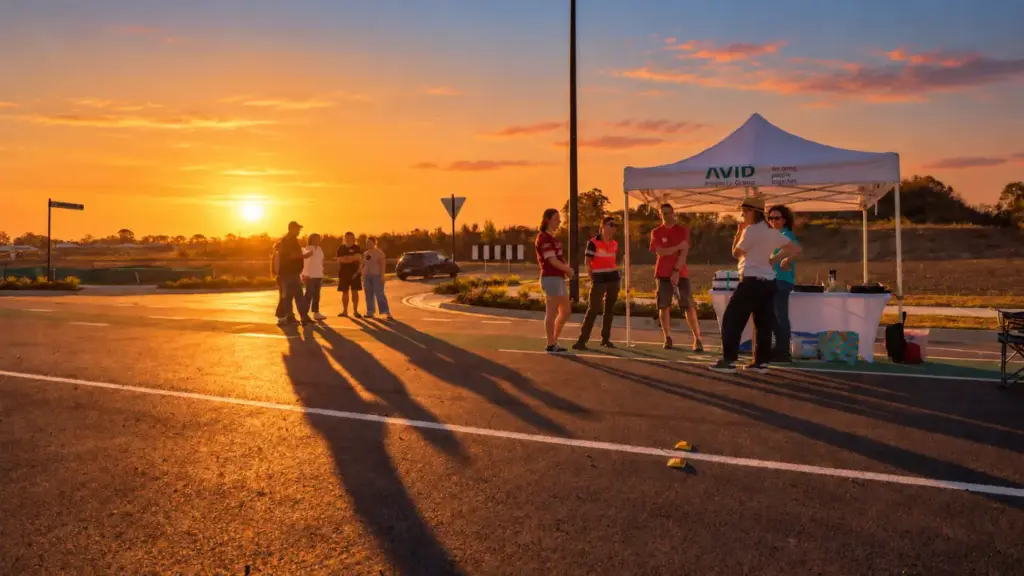 People gather beneath a canopy at sunset